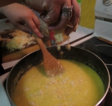 Stirring and adding the grated cheese.